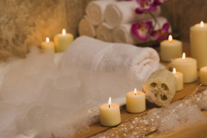 A luxurious bath tub adorned with candles, soap, and flowers, creating an ambiance of relaxation and serenity.